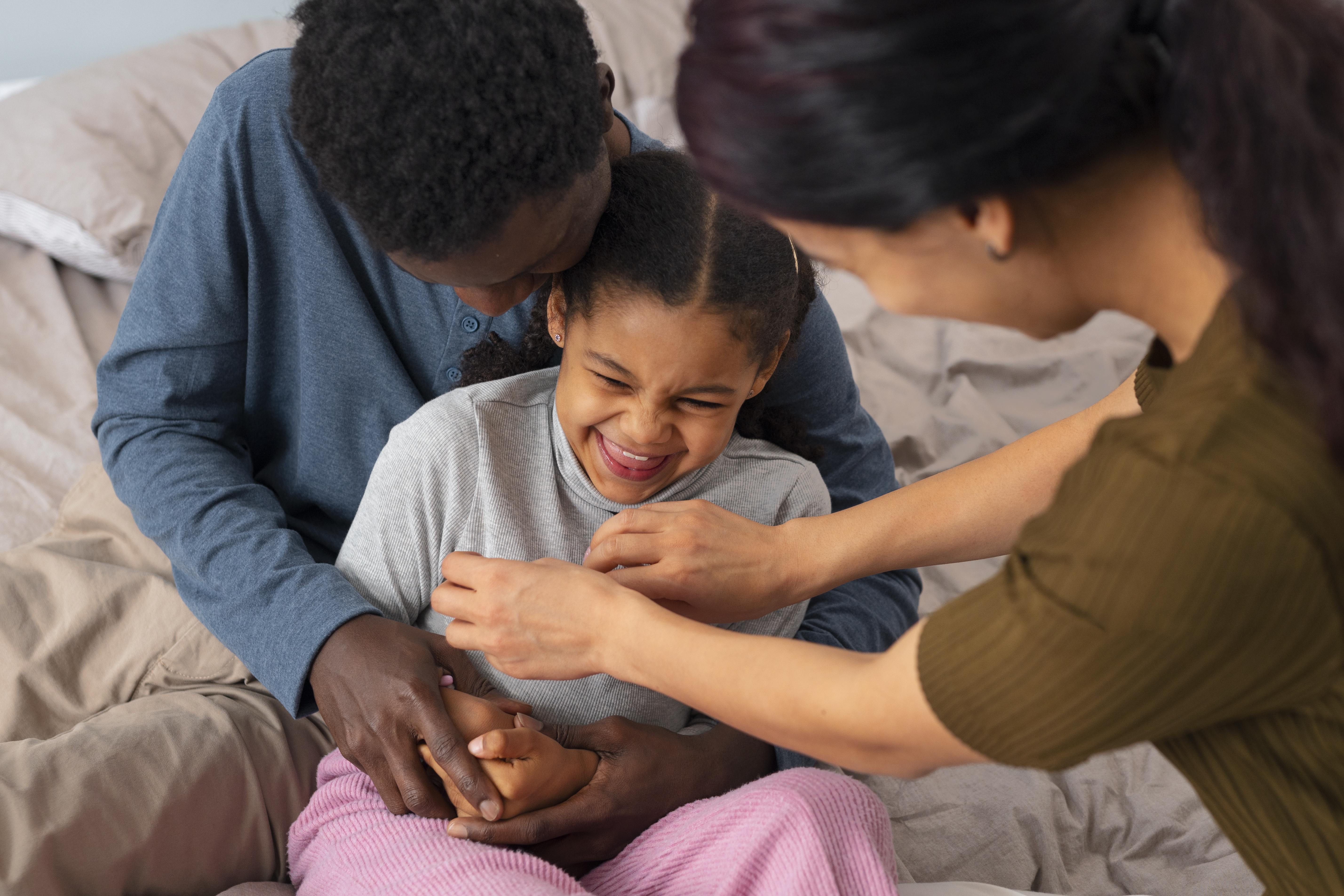 parents and young girl smiling on the couch