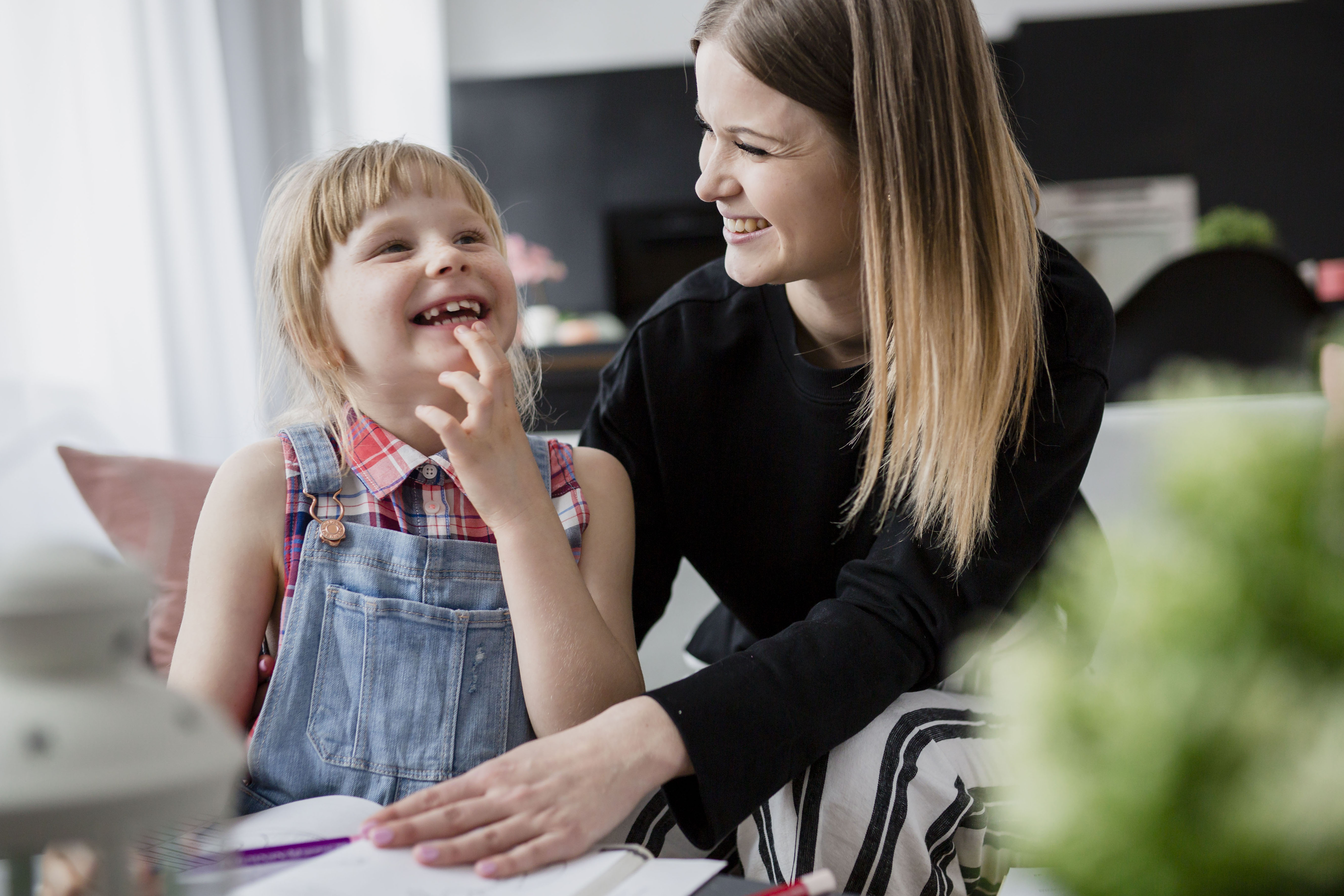 Caregiver and young girl smiling together
