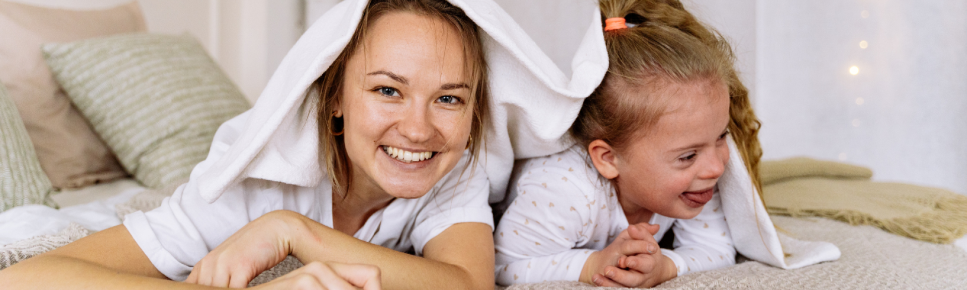 mother and daughter smiling in bed