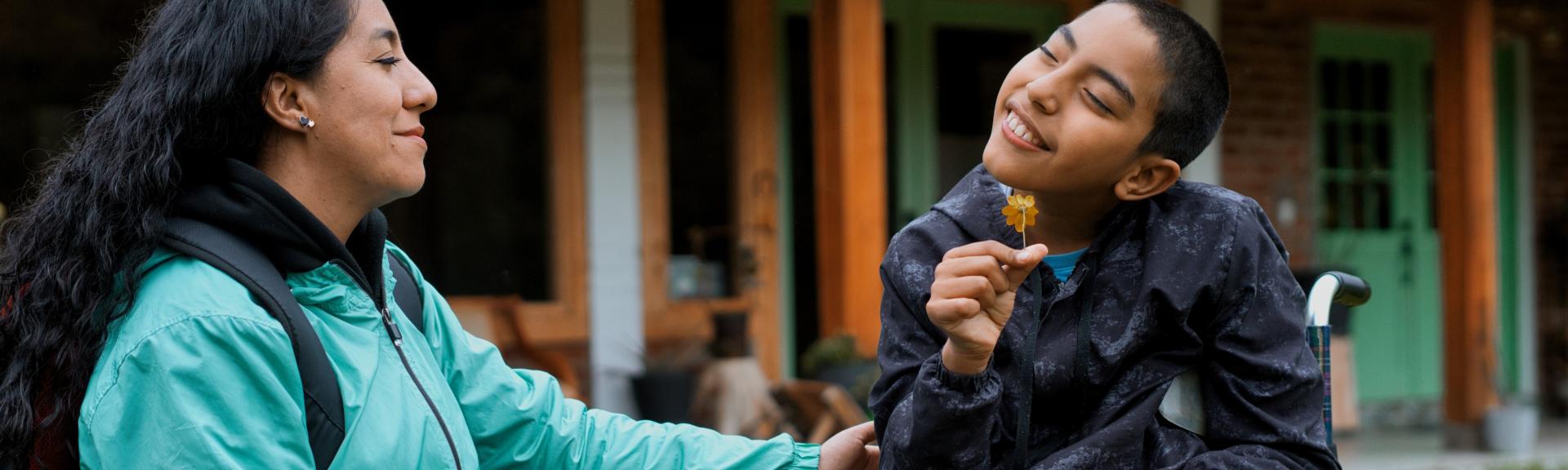mother and son sitting in wheelchair, smiling
