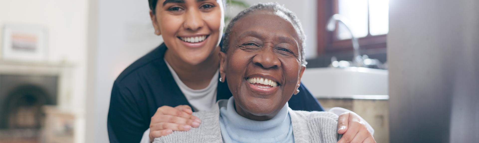 caregiver and elder woman smiling