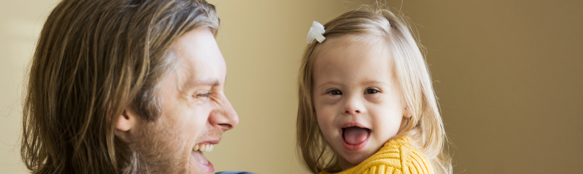 father smiling at daughter with down syndrome