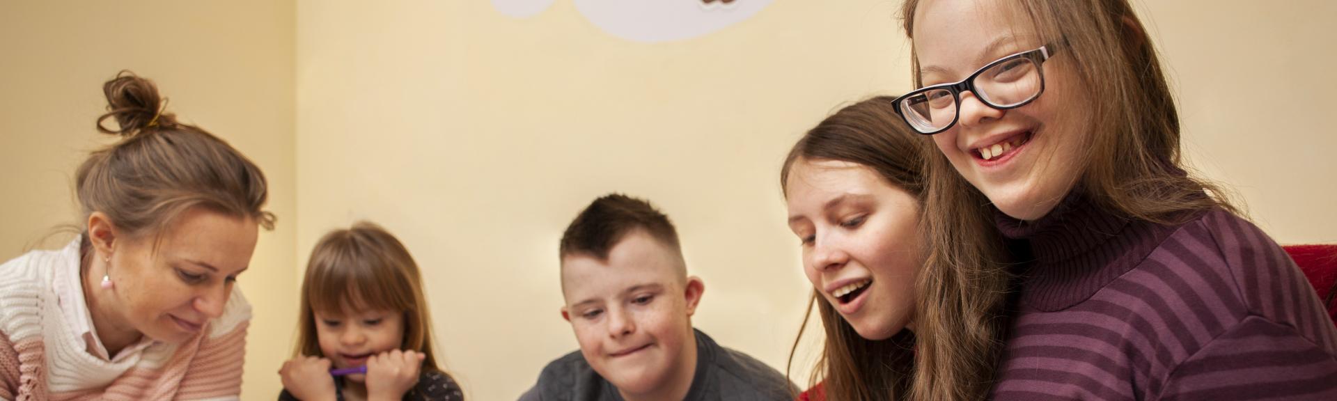 happy girl with down syndrome posing while drawing