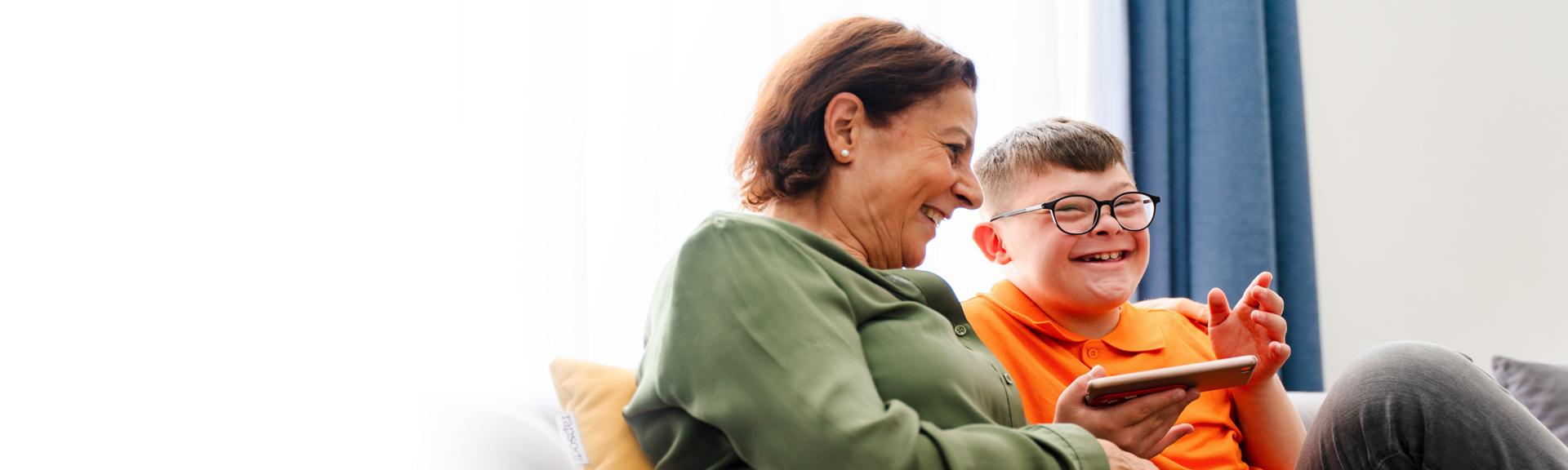 Female caregiver laughing with young boy