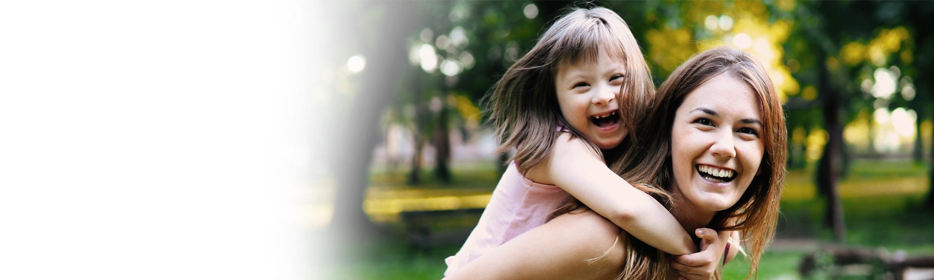 Young woman carrying young girl on back