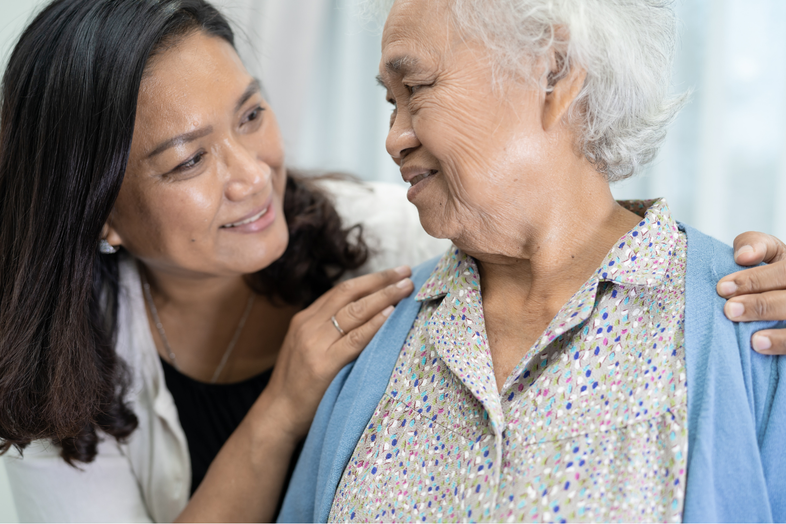 Elder adult and female caregiver smiling