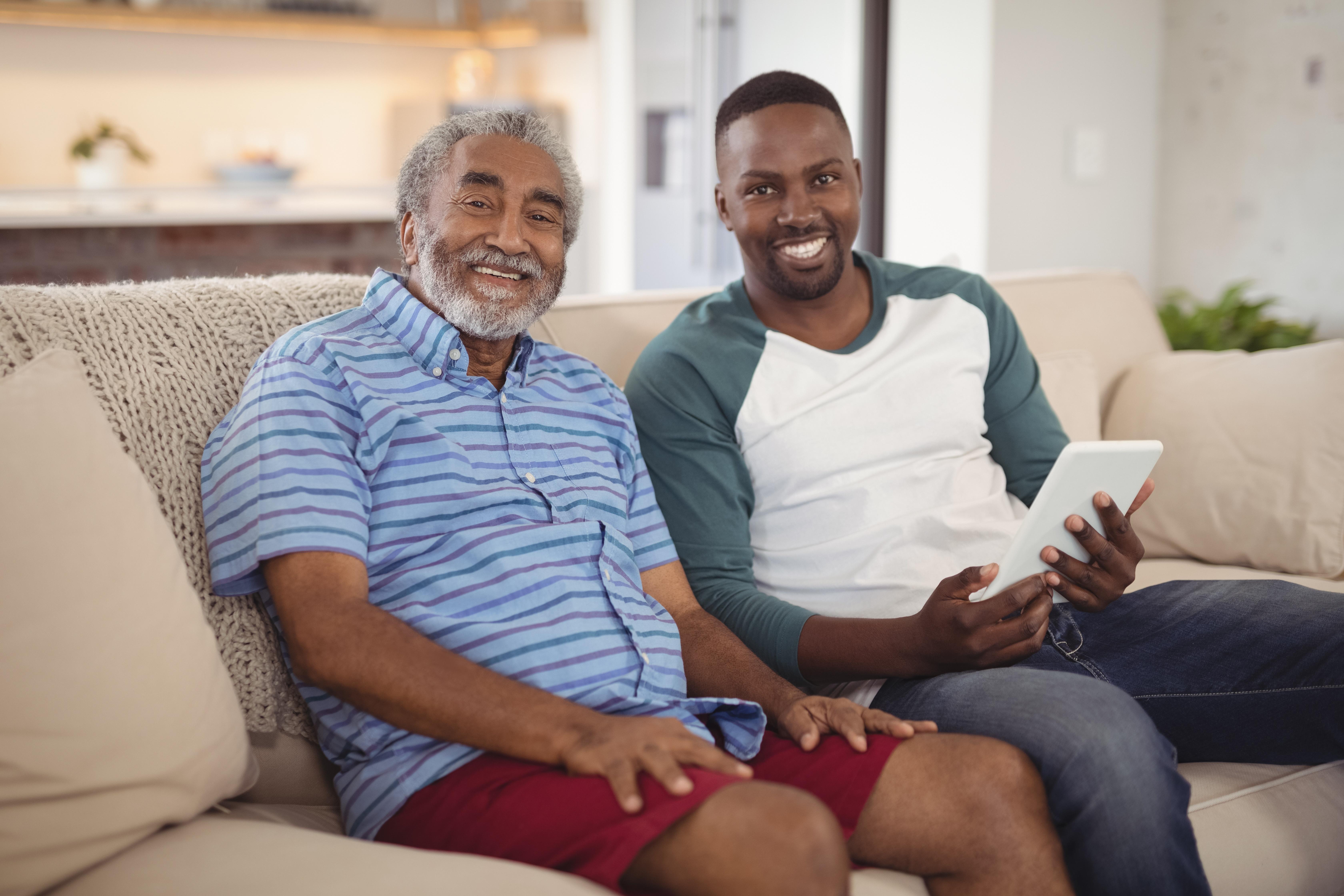 Senior male and male caregiver holding tablet