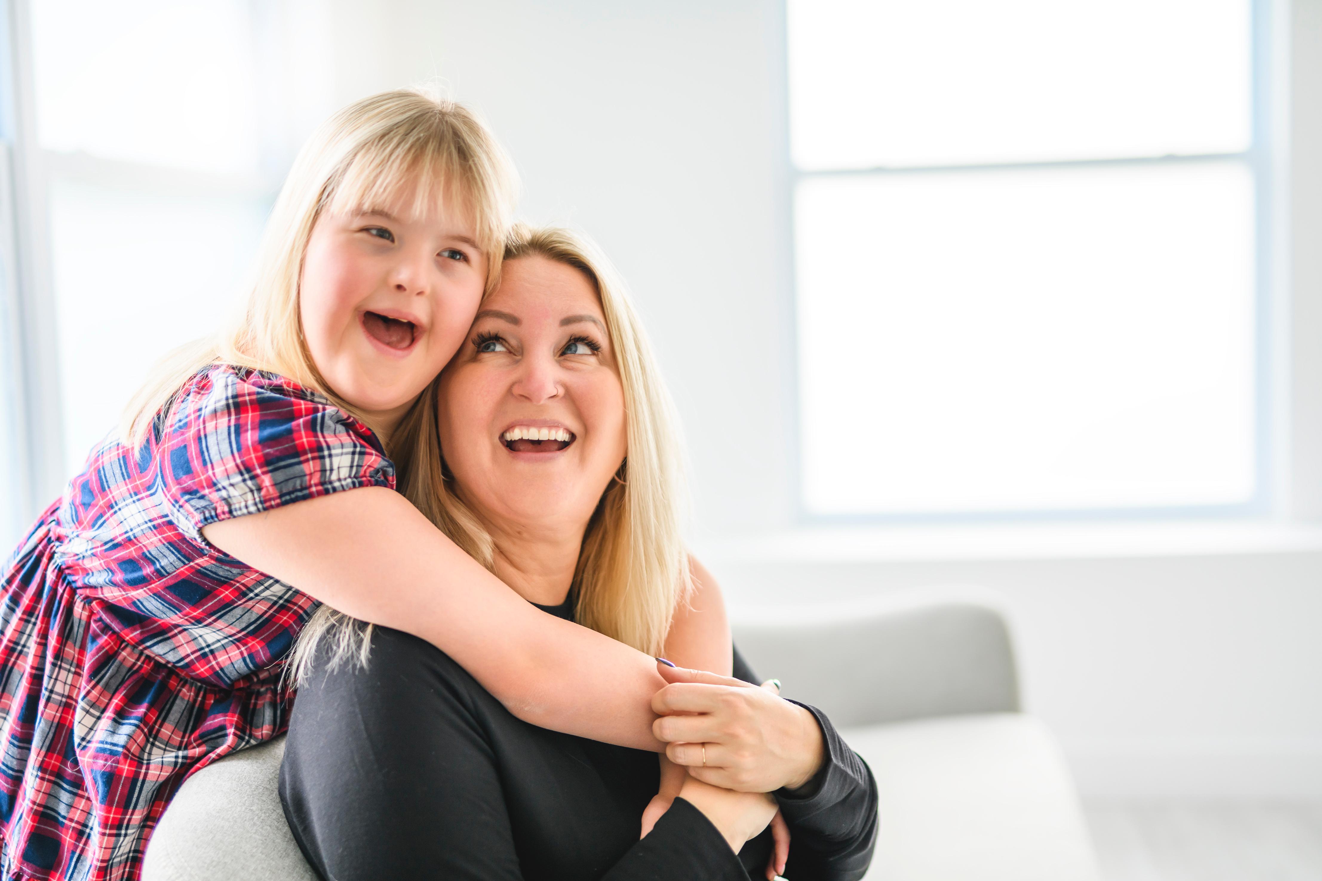 Little girl hugging woman
