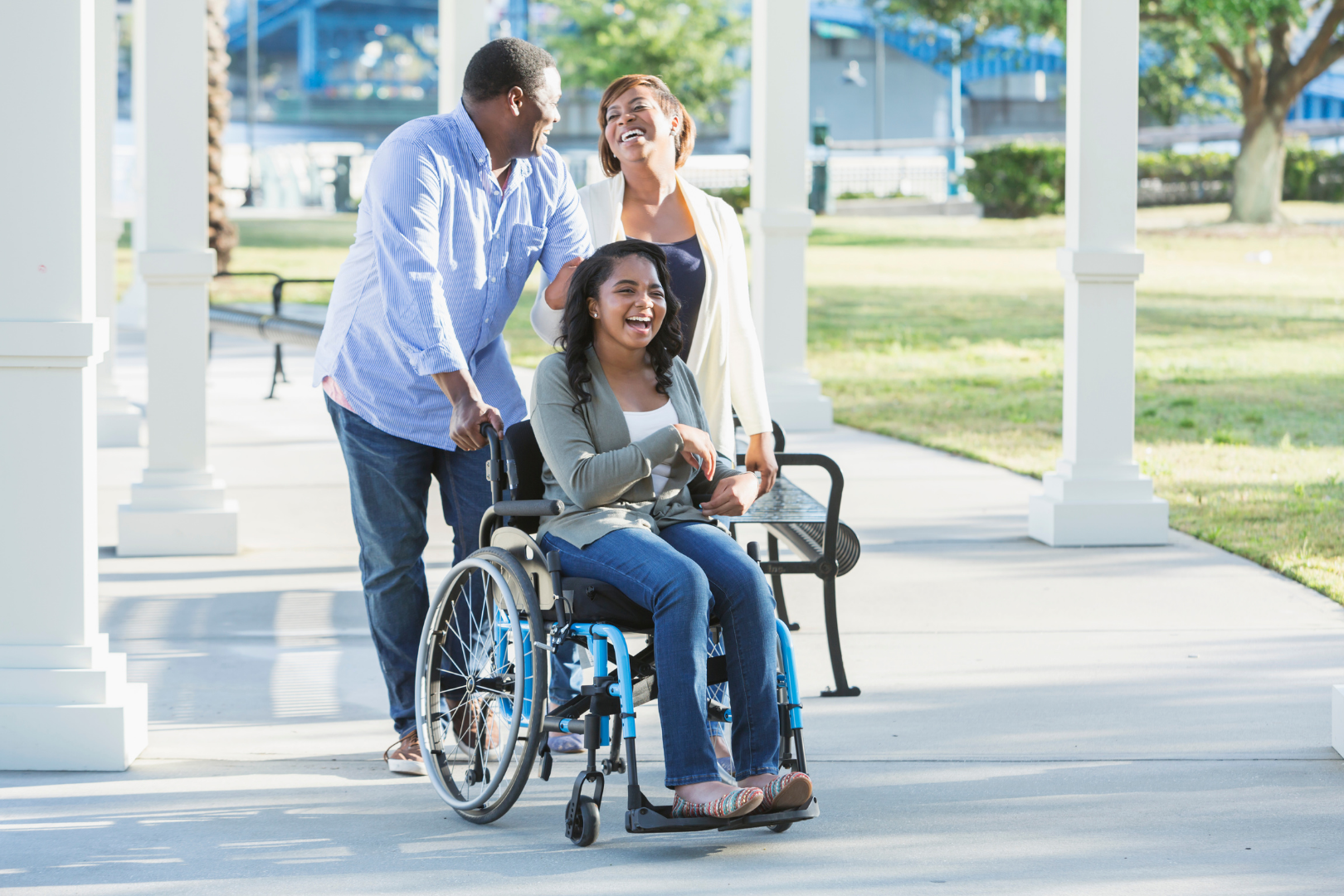 wheelchair using young adult smiling with mother and father