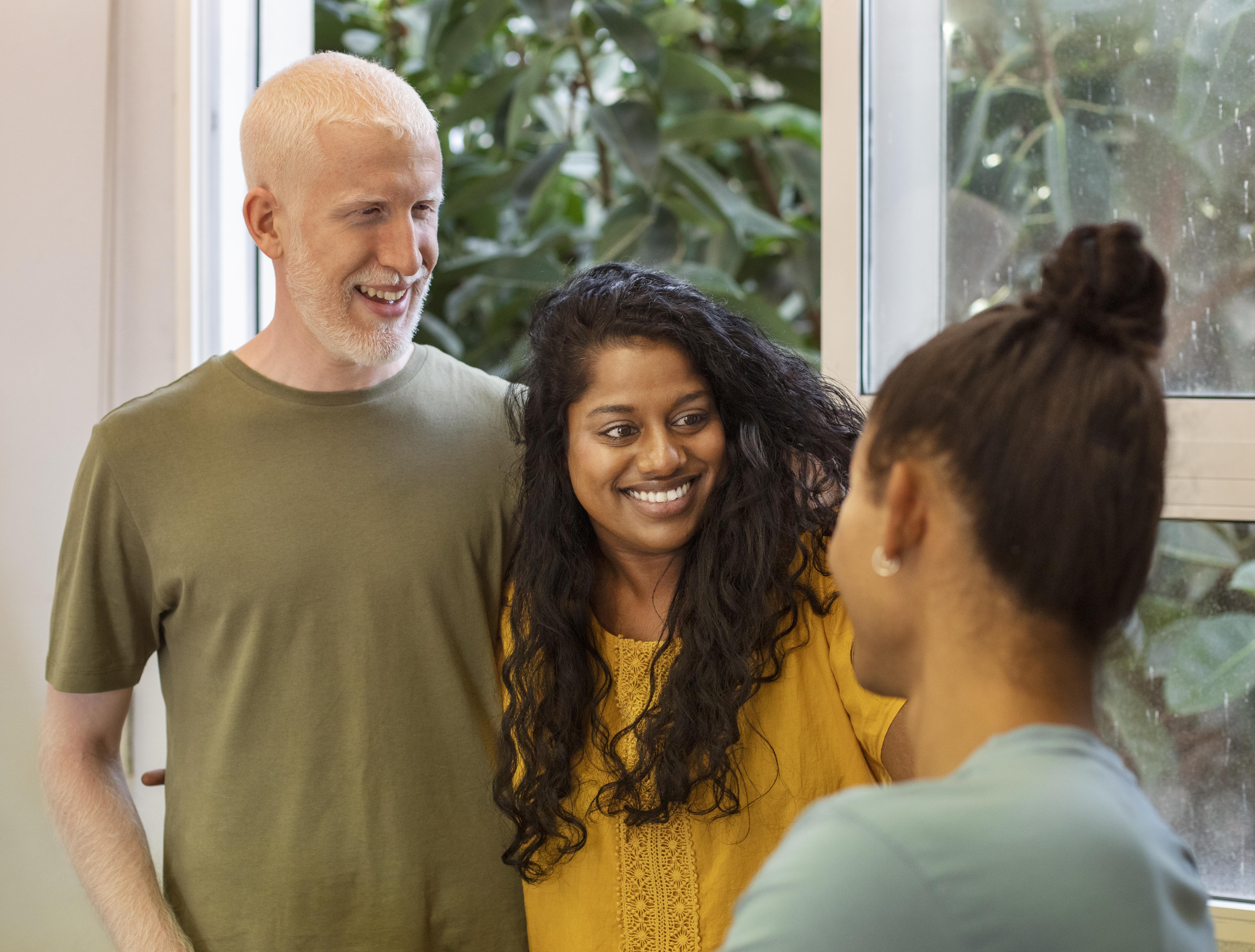 two adults smiling at a woman