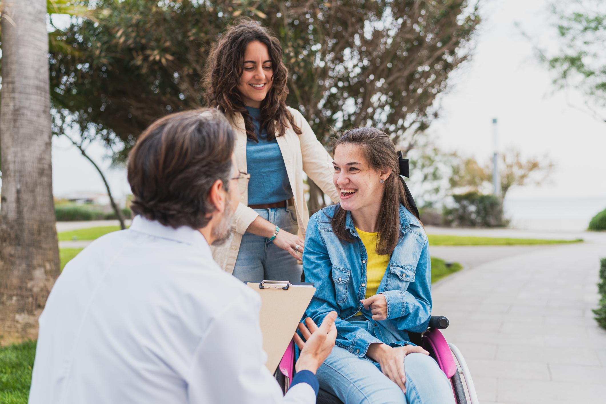 Young woman in wheelchair with caregiver