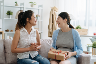 two women exchanging gifts, smiling